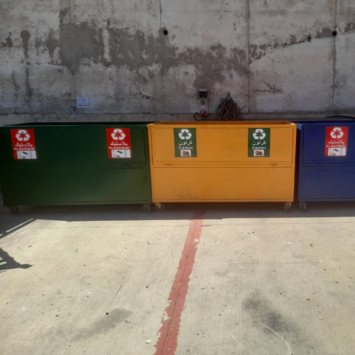 Gestion des déchets 62 Une vue similaire des trois grands conteneurs de recyclage industriels de l'image précédente, alignés contre le même mur en béton. Le bac vert (à gauche) et le bac jaune (au centre) sont bien positio